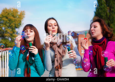 Drei junge schöne Frauen sprengen Luftblasen Stockfoto