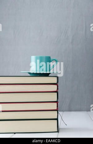 Blaue Kaffeetasse auf Stapel Bücher Stockfoto