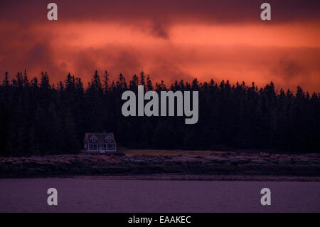 Sonnenuntergang über eine isolierte Küsten Zuhause, Bereich zwischen Flora und Fauna und Wolken mit starkem rosa-Orange Licht beleuchtet. Stockfoto