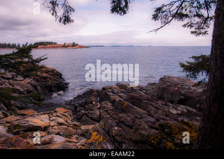 Seascape Vista vorbei an einem felsigen Ufer mit Blick auf Insel und Horizont in der Ferne. Stockfoto