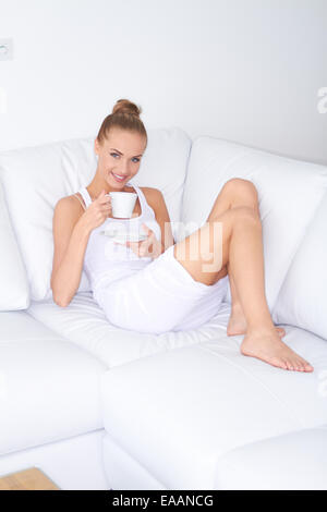 Hübsche Frau mit Kaffee zu Hause entspannen Stockfoto