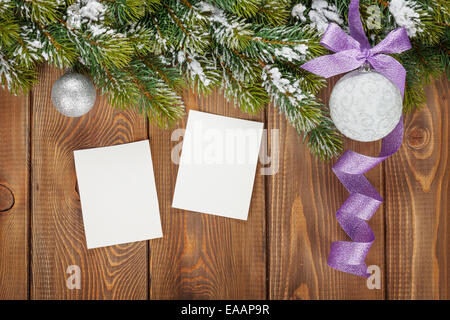 Weihnachts-Dekor und leere Bilderrahmen über hölzerne Hintergrund mit Schnee Tanne Stockfoto