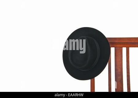 Schwarzen Hut hängen, ein Alter Stuhl, isoliert auf weiß Stockfoto
