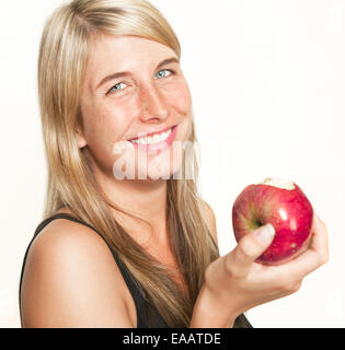 junge Frau mit langen Haaren hält einen roten Apfel in der Hand, weißer Hintergrund Stockfoto