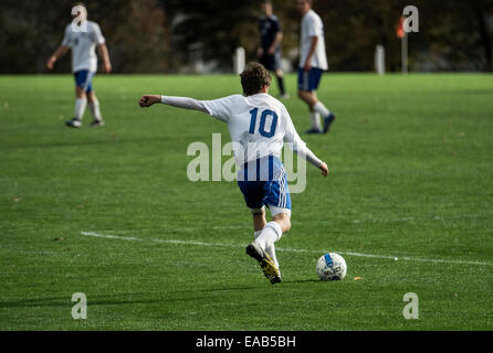 Jugend-Fußball-Spieler nimmt einen Freistoß während eines Spiels Spiel. Stockfoto