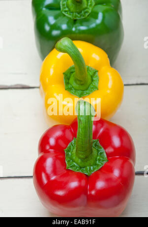 drei frische Paprika über alten Holztisch Stockfoto