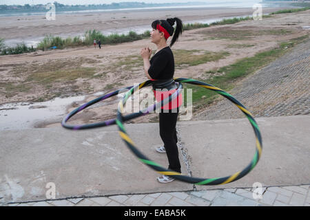 Frau mit Hoola Creolen Übung am Ufer des Mekong-Flusses in Vientiane, der Hauptstadt von Laos, Südostasien, Asien, Stockfoto
