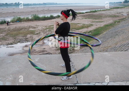Frau mit Hoola Creolen Übung am Ufer des Mekong-Flusses in Vientiane, der Hauptstadt von Laos, Südostasien, Asien, Stockfoto