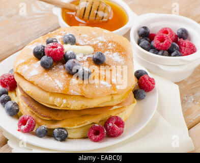 Pfannkuchen mit Honig und Beeren garniert. Selektiven Fokus Stockfoto