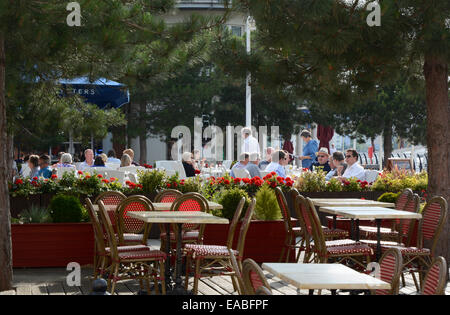 Menschen, die an den Tischen im Außenbereich des Restaurants im Einkaufszentrum Gunwharf Quays. Portsmouth. Hampshire. England Stockfoto