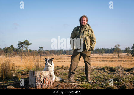 Hirt mit seinem Border Collie Schäferhund am Nationalpark Loonse En Drunense Duinen in den Niederlanden Stockfoto