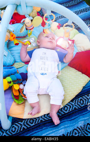 Baby spielt auf Matte mit Fitnessraum über mobile Stockfoto