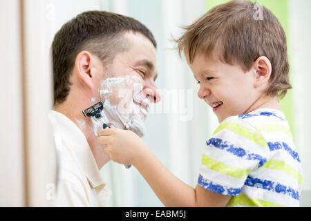 Kind Junge versucht, seinen Vater zu rasieren Stockfoto