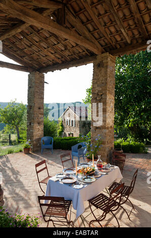 Gedeckten Tisch für Abendessen auf der überdachten Terrasse des Bauernhauses im umbrischen Ausläufern Stockfoto