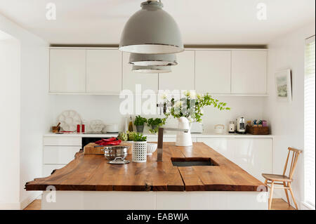 Drei Industrielampen oberhalb Elm-Spitze Küche Insel Stockfotografie