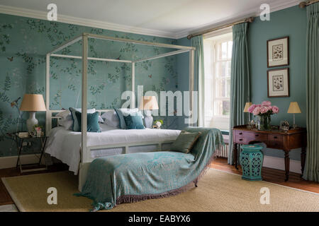 De Gournay Chinoiserie Seidentapeten in eleganten Schlafzimmer mit Himmelbett aus Ocker und Sisal Teppich Stockfoto