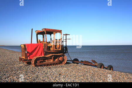 Caterpillar Tractor und Bootsanhänger am Strand von Weybourne, Norfolk, England, Vereinigtes Königreich. Stockfoto