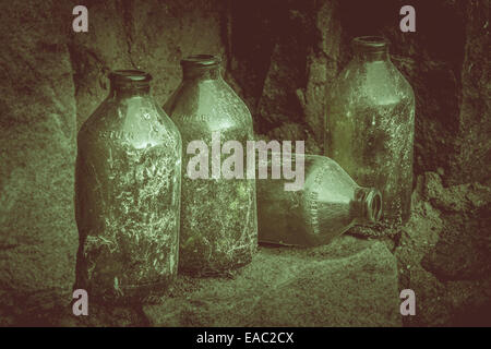 Alte Bierflaschen auf einer Steinmauer. Stockfoto