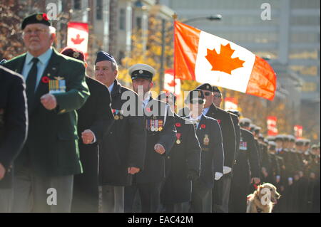 London, Ontario, Kanada. 11. November 2014. Hinter und anwesende Mitglieder der kanadischen Streitkräfte und die Öffentlichkeit versammeln sich am Cenotaph in London, Ontario, Gedenktag zu beobachten. An diesem Feiertag halten bundesweite Gemeinschaften Zeremonien, um gefallene Soldaten Respekt zollen. Bildnachweis: Jonny White/Alamy Live-Nachrichten Stockfoto