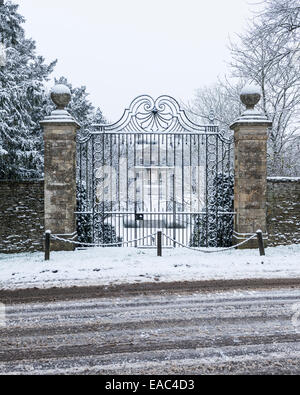 Cornwell Manor gesehen durch seine schmiedeeisernen Eingangstore im Schnee Stockfoto