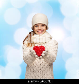 träumende Mädchen in Winterkleidung mit roten Herzen Stockfoto