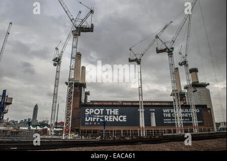 Krane umgeben Battersea Power Station auf einem grauen Herbsttag mit halben Kamin, wie es in Wohnungen saniert ist Stockfoto