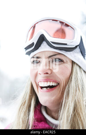 Glückliche Frau lächelnd mit Googles Ski im winter Stockfoto