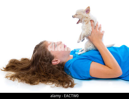 Entspanntes Kind Mädchen und Welpe Gähnen Chihuahua Hund liegen glücklich auf weißem Hintergrund Stockfoto