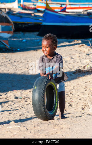 Madagassische Kind spielt mit einem gebrauchten Reifen, Morondava, Toliara Provinz, Madagaskar Stockfoto