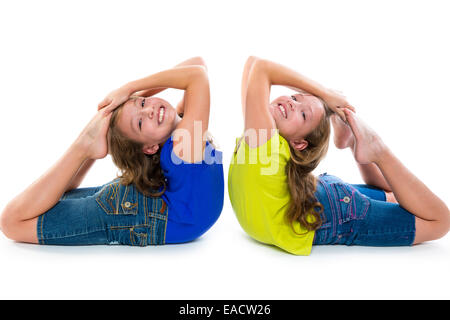 Twin Kind Schwestern symmetrische flexibel spielen glücklich auf weißem Hintergrund Stockfoto