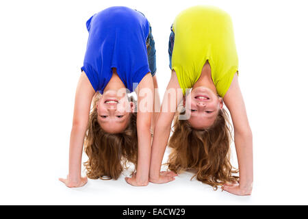 Zwillingsschwestern Kind spielen als flexible Schlangenmensch glücklich auf weißem Hintergrund Stockfoto