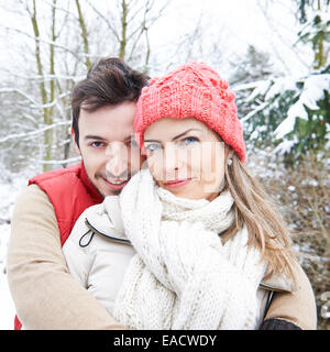 Glückliches Paar, umarmen, draußen im Winter im Schnee Stockfoto