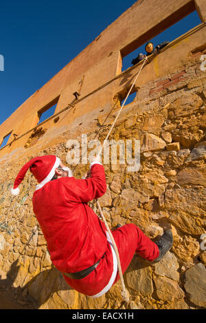 Santa, Kletterwand, während ein gruseliges Halloween-Monster auf ihn wartet Stockfoto