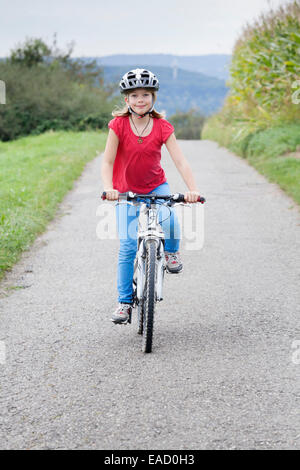 Mädchen, 9 Jahre, mit dem Fahrrad einen Helm zu tragen Stockfoto
