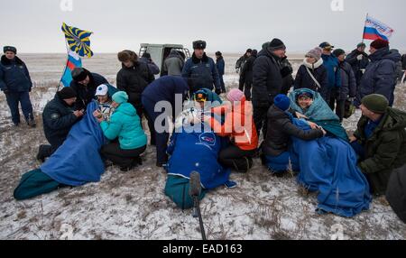 ISS-Expedition 41 Mannschaft Alexander Gerst von der European Space Agency, links, Kommandant Max Suraev der russischen Federal Space Agency, Zentrum und NASA-Astronaut Reid Wiseman, sitzen auf Stühlen vor der Sojus TMA - 13M Kapsel nur wenige Minuten nach der Landung in einer abgelegenen Gegend 10. November 2014 in der Nähe von Arkalyk Kasachstan. Surajew, Wiseman und Gerst Rückkehr zur Erde nach mehr als fünf Monate an Bord der internationalen Raumstation ISS, wo sie als Mitglieder der Expedition 40 und 41 Mannschaften dienten. Stockfoto