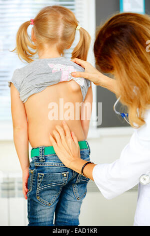 Kinderarzt Prüfung kleines Mädchen mit Rückenproblemen. Stockfoto