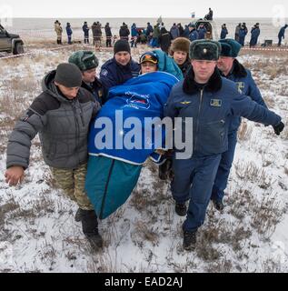 ISS-Expedition 41 Kommandant Max Suraev der russischen Federal Space Agency wird zum medizinischen Zelt außerhalb der Sojus-Kapsel, nur wenige Minuten nach der Landung in einer abgelegenen Gegend 10. November 2014 in der Nähe von Arkalyk Kasachstan durchgeführt. Surajew, Wiseman und Gerst Rückkehr zur Erde nach mehr als fünf Monate an Bord der internationalen Raumstation ISS, wo sie als Mitglieder der Expedition 40 und 41 Mannschaften dienten. Stockfoto