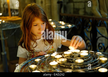 Mädchen, die Beleuchtung einer hingebungsvollen Kerze an Notre-Dame de Paris oder die Kathedrale Notre-Dame, Ile De La Cité, 4. Arrondissement, Paris Stockfoto