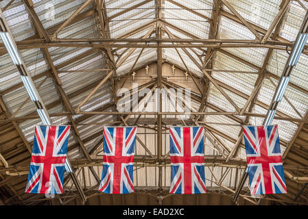 Vier "Union Jacks" hängt von der Decke top im Londoner Victoria Station Stockfoto