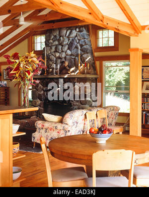 Land Haus Stil Wohnzimmer mit Tisch, Sofa und Kamin Stockfoto