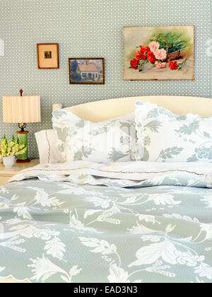 Bett mit floral gemusterte Decken und Kissen Stockfoto