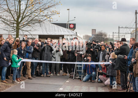 Krommenie, Niederlande. 12. November 2014. 12. November 2014, Krommenie, Niederlande. Niederländische Minister für wirtschaftliche Angelegenheiten Henk Kamp soll das weltweit erste Fahrradweg hergestellt aus Solarzellen, in Krommenie, 25 Kilometer nördlich von Amsterdam zu öffnen. Auf einem Fahrrad. Normalerweise ist die Eröffnung von einem Radweg streng eine lokale Angelegenheit in den Niederlanden. Diesein ist etwas Besonderes: nur 70 m (230ft) lang, es ist die weltweit erste Fahrradweg aus Solarzellen hergestellt. Hier warten einheimische und ausländische Presse (Deutsch Russisch Chinesisch unter ihnen) alle für ihn durch das Banner zu reiten. Bildnachweis: Wiskerke/Alamy Liv Stockfoto