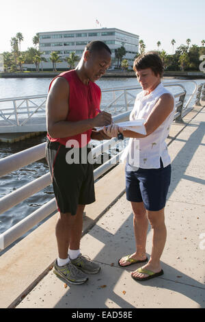 Afrikanische Amerikaner Unterzeichnung ein Papier auf dem Riverwalk bei Rossi Park in Bradenton, Florida, USA Stockfoto