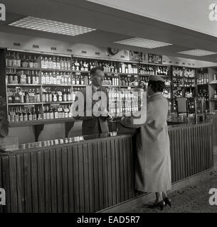 1950er Jahre, historische Bild einer Dame Passagier am Flughafen duty free Counter, Flughafen Dublin, Irland. Stockfoto