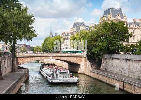 Paris, Frankreich - 11. August 2014: Weiße touristische Passagierschiff von Bateaux-Mouches betrieben geht unter der Brücke am Seineufer Stockfoto