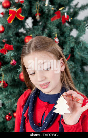 Mädchen hält ein Ornament des Weihnachtsbaumes Stockfoto