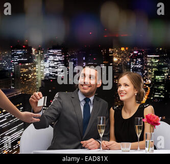 lächelnde paar zum Abendessen mit Kreditkarte bezahlen Stockfoto