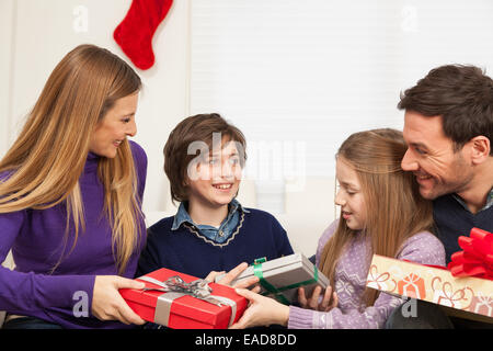 Glückliche Familie öffnen das Weihnachtsgeschenk Stockfoto