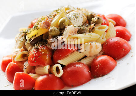 Pasta-Salat mit Tomaten, Mozzarella und Oliven auf Platte Stockfoto
