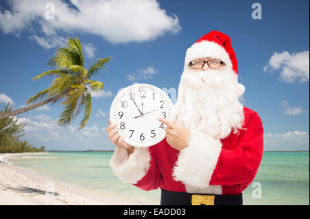 Mann im Kostüm des Weihnachtsmannes mit Uhr Stockfoto